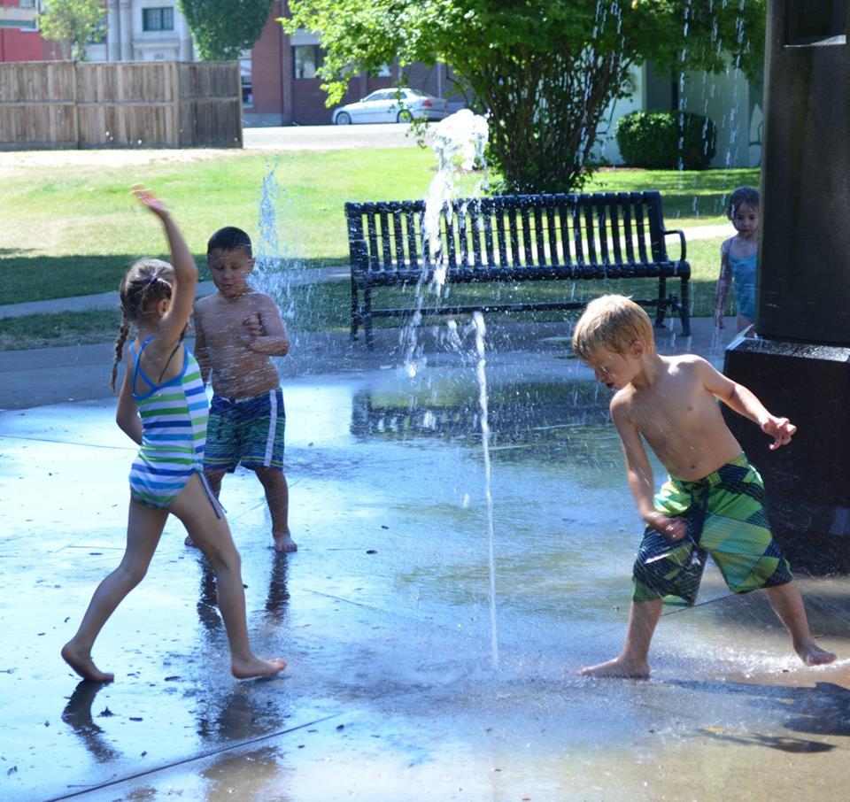 Children from the CDC play in the fountain at the park