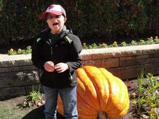 Ethan standing next to a large pumpkin