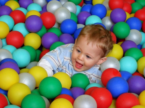 A toddler plays in a ball pit