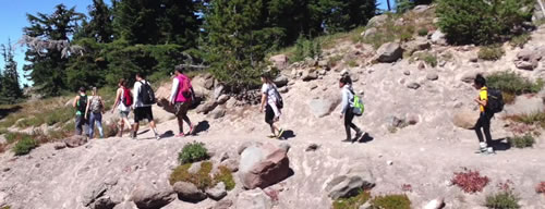 group of students with backpacks on hiking trail