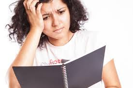 Girl with frustrated expression reads textbook