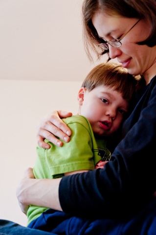 A mother cuddles with her little boy, who has autism