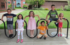 Six children playing on a bike rack